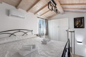 a white bedroom with a bed with towels on it at Casa Mary Vicino a Camaiore in Camaiore