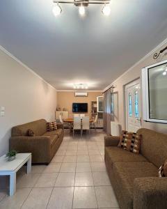 ein Wohnzimmer mit zwei Sofas und ein Esszimmer in der Unterkunft The Βeach - Family House in Amaliada