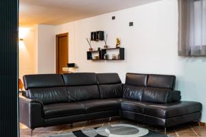 a black leather couch in a living room at A Casa Di Gigi in Latina