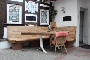 a wooden table with two chairs and a clock on a wall at Pension "Brückenschänke" in Nassau