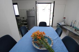 une table bleue avec un bol de fleurs sur elle dans l'établissement Apartments Sonnenblume, à Funtana