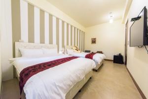 2 letti in una camera con TV di Iwaiker B&B a Città di Hualien