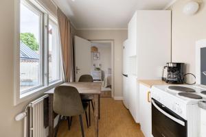 a small kitchen with a wooden table and a window at Cozy studio in separate building in Visby