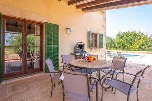 a patio with a table and chairs and a pool at Sa Xigala in Algaida