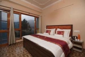 a bedroom with a large bed and a large window at Hill View 4br Apt Near Shimla Mall Road in Shimla