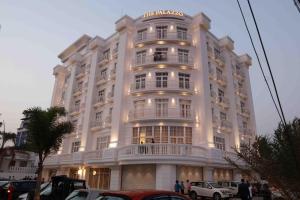 a large white building with people on the balcony at The Palazzo Chakolas in Trichūr +11 photos