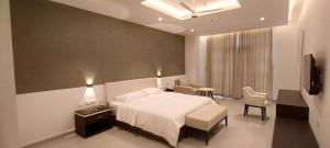 a bedroom with a white bed and a table and chairs at The Palazzo Chakolas in Trichūr