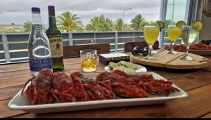 a plate of lobsters on a table with a bottle of wine at Velddrif Riverside Guesthouse in Velddrif