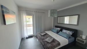 a bedroom with a bed with blue pillows and a window at Ferienwohnung Adriaperle Villa Casper mit Whirlpool in Palit