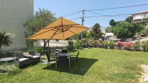 a table and chairs with an umbrella in a yard at Ferienwohnung Adriaperle Villa Casper mit Whirlpool in Palit
