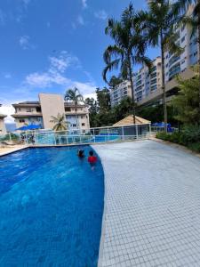a large swimming pool with a person in the water at Apartamento Bela Vista Porto Real Resort in Mangaratiba
