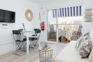 a white living room with a table and chairs at Apartamento De Diseño Con Piscina Junto Al Mar GANDIAZAR IV in Playa de Gandia