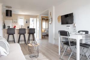 a living room and kitchen with a table and chairs at Apartamento De Diseño Con Piscina Junto Al Mar GANDIAZAR IV in Playa de Gandia