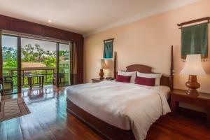 sypialnia z dużym łóżkiem i balkonem w obiekcie Prince Angkor Hotel & Spa w Siem Reap