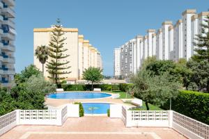 a view of buildings and a swimming pool in a city at Apartamento De Diseño Con Piscina Junto Al Mar GANDIAZAR IV in Playa de Gandia