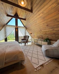 a room with two beds and a large window at Grzeszne Chatki - Smerek in Smerek