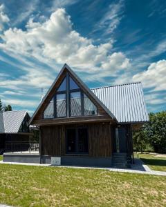 a house with a gambrel roof with a large window at Grzeszne Chatki - Smerek in Smerek