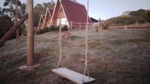 a swing in a field in front of a church at CascataDiamantePousada in Laurentino +33 photos