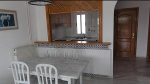 a kitchen with a table and chairs and a sink at Apartamento en Golf Center Pueblo in Roquetas de Mar