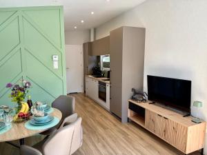 a living room with a television and a table with chairs at Natursee-Chalet,Spa mit Hot Tub,Jacuzzi,Sauna,Ponyhof,angeln in Twist