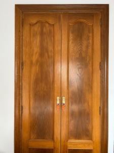 a wooden cabinet with two doors next to a wall at Apartamento en Golf Center Pueblo in Roquetas de Mar
