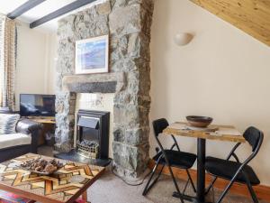 a living room with a stone fireplace at Cae Tanws Bach in Dolgellau
