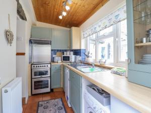 a kitchen with blue cabinets and a stove top oven at Cae Tanws Bach in Dolgellau