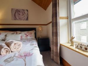 a bedroom with a bed with towels on it at Cae Tanws Bach in Dolgellau