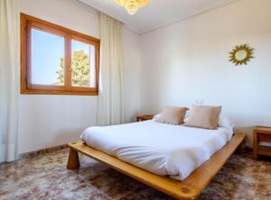 a bedroom with a large white bed with a window at Villa Can Cardona Sea views Perfect 4 families in Sant Rafael de Sa Creu +37 photos
