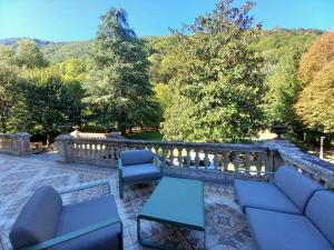 a patio with couches and chairs and a fence at Villa du Lys in Luchon