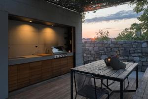 a outdoor kitchen with a table and a counter at Kambra in Dutovlje