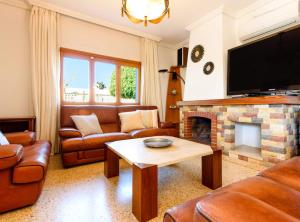 a living room with leather furniture and a fireplace at Villa Can Cardona Sea views Perfect 4 families in Sant Rafael de Sa Creu