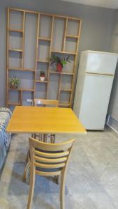 a wooden table with a chair and a refrigerator at Dpto 1 in San Justo