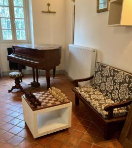 a living room with a piano and a chess board at Cottage authentique et chaleureux entre Pau et Lourdes pour 7 personnes in Nousty +16 photos