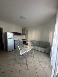 a kitchen with a table and chairs and a couch at Appartamento vista mare in Grottammare +10 photos