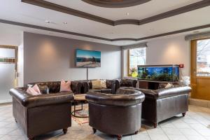 a living room with leather furniture and a flat screen tv at Alpenhotel Ramsauerhof in Ramsau im Zillertal