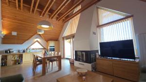 a living room with a large television and a table at Komforna planinska kuća za odmor in Mrkopalj