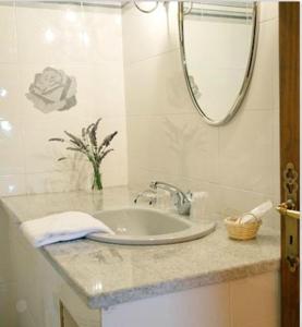een badkamer met een wastafel en een spiegel bij Logis Hôtel Restaurant Les Géraniums in Le Barroux