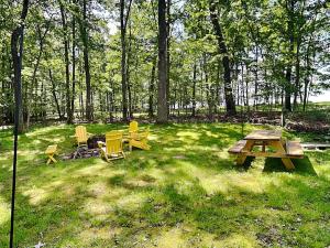 a picnic table and chairs in a field with trees at In The Middle in Oakland