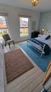 a bedroom with a bed and a chair and a window at Cosy Village Retreat in Long Buckby