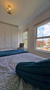 a bedroom with a large bed with a large window at Cosy Village Retreat in Long Buckby