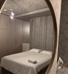 a bedroom with a bed and a mirror at Spa Apartmani in Nikšić +4 photos