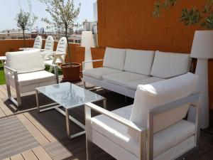 a patio with white furniture and a table and chairs at Your Home in Barcelona Apartments in Barcelona