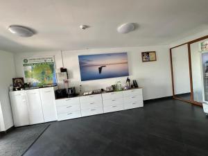 a room with white cabinets and a large painting on the wall at Pensiunea La Miluta in Caraorman