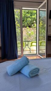 a blue towel laying on a bed in front of a window at Filoxenia Residence in Palasë