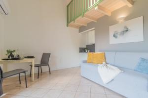 a living room with a blue couch and a table at Monolocale con soppalco Brezza del lario by Varenna Holidays in Dervio