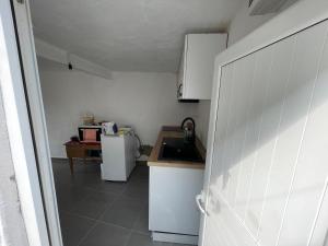 a small kitchen with a sink and a refrigerator at Myra in Himare +14 photos