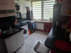a small kitchen with a sink and a stove at Pokoje do wynajęcia in Michałowo