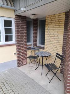 a patio with a table and chairs and a brick wall at Naturskønt nær Ribe Vikingecenter, se og oplev den gamle by Ribe in Ribe