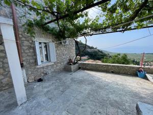 a stone house with a window and a patio at Myra in Himare